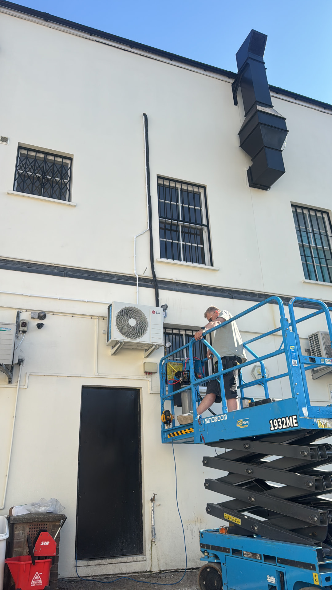 Air conditioning engineer working from a powered access platform