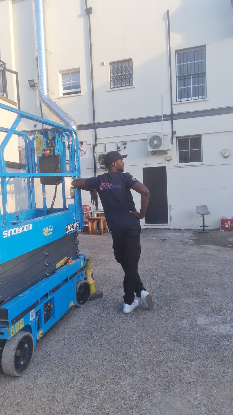 UK Gas Plumbers engineer beside powered access equipment during an air conditioning installation